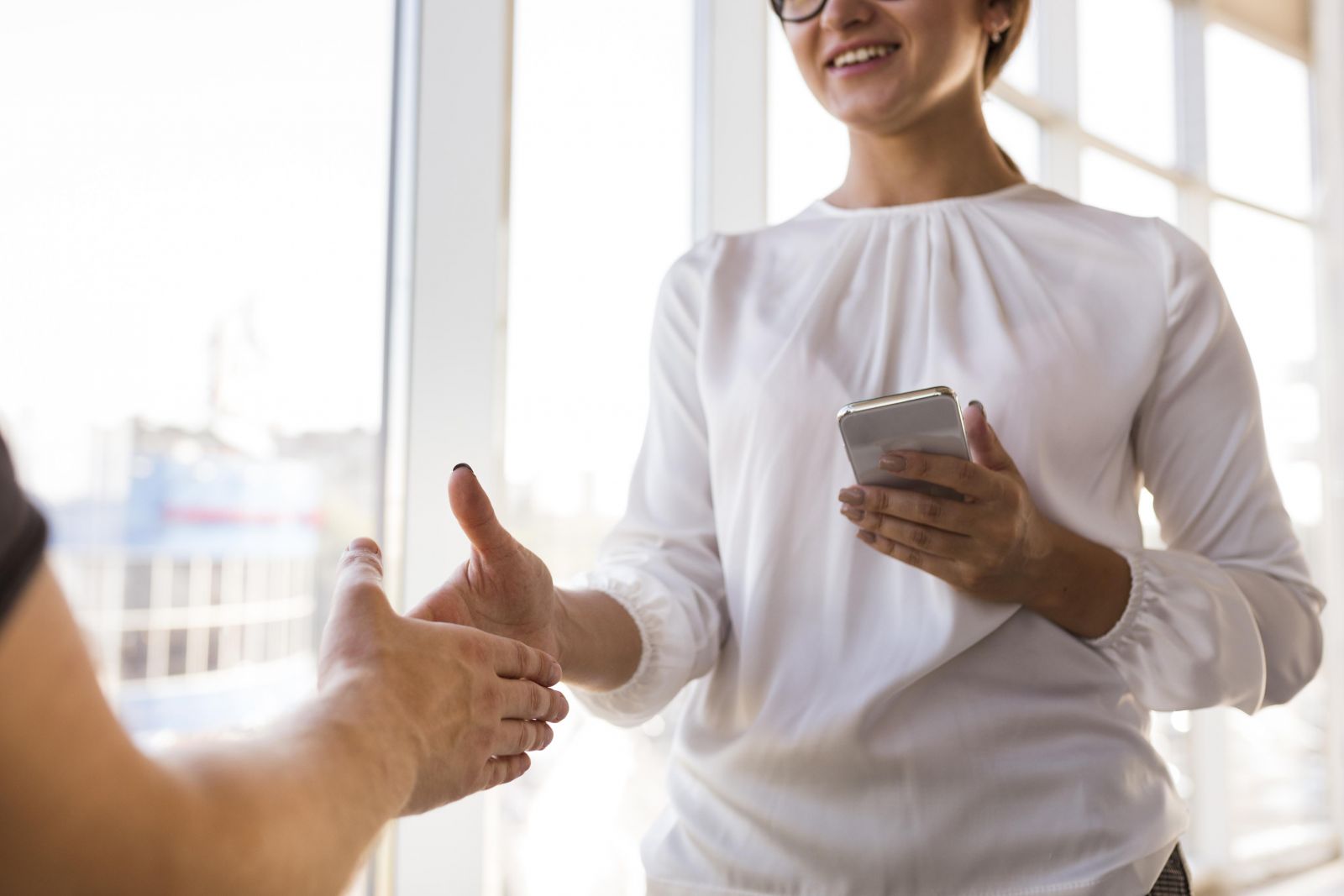 Femme d'affaires souriante saluant lors d'une visioconférence